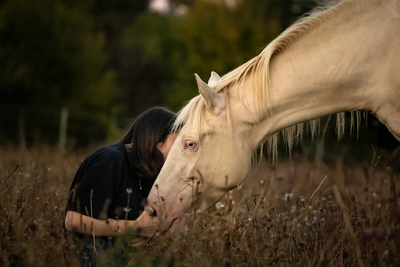 Elia Grimaud with a white horse in an open field